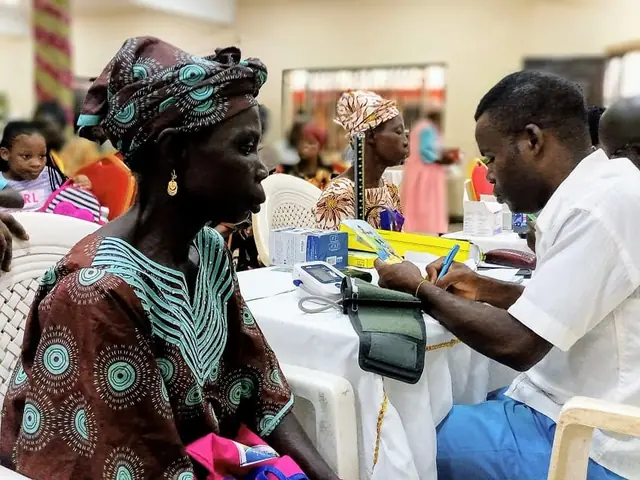 A health worker taking an elderly woman's blood pressure