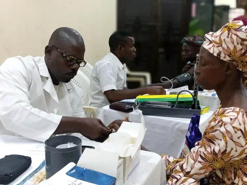 A health worker testing an elderly woman during a health screening